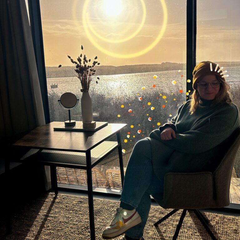 Wendy on a chair at dawn, looking to the side while the sunlight pours into the room