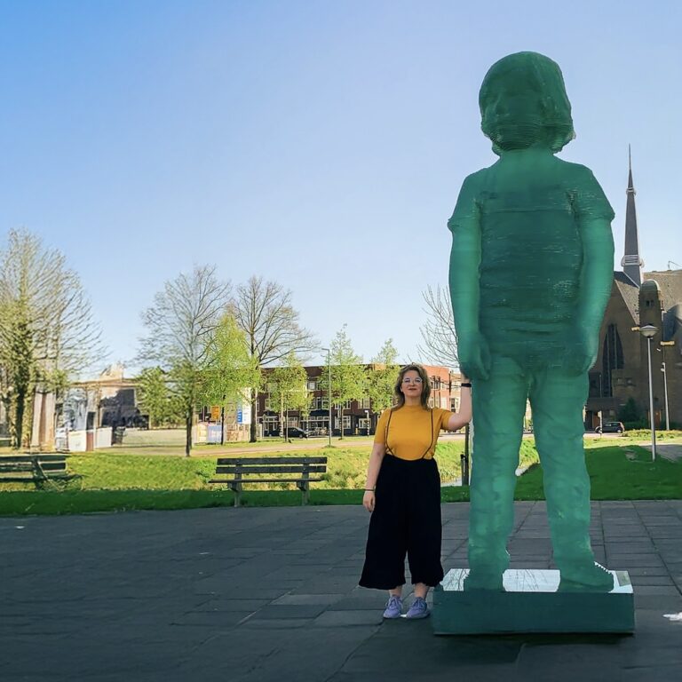 Wendy holding hands with a statue of a child